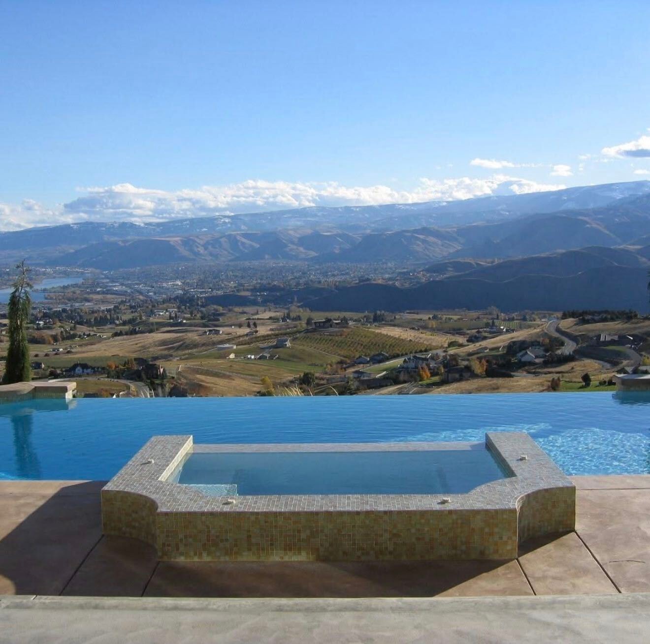 Infinity pool and spa with panoramic valley and mountain views