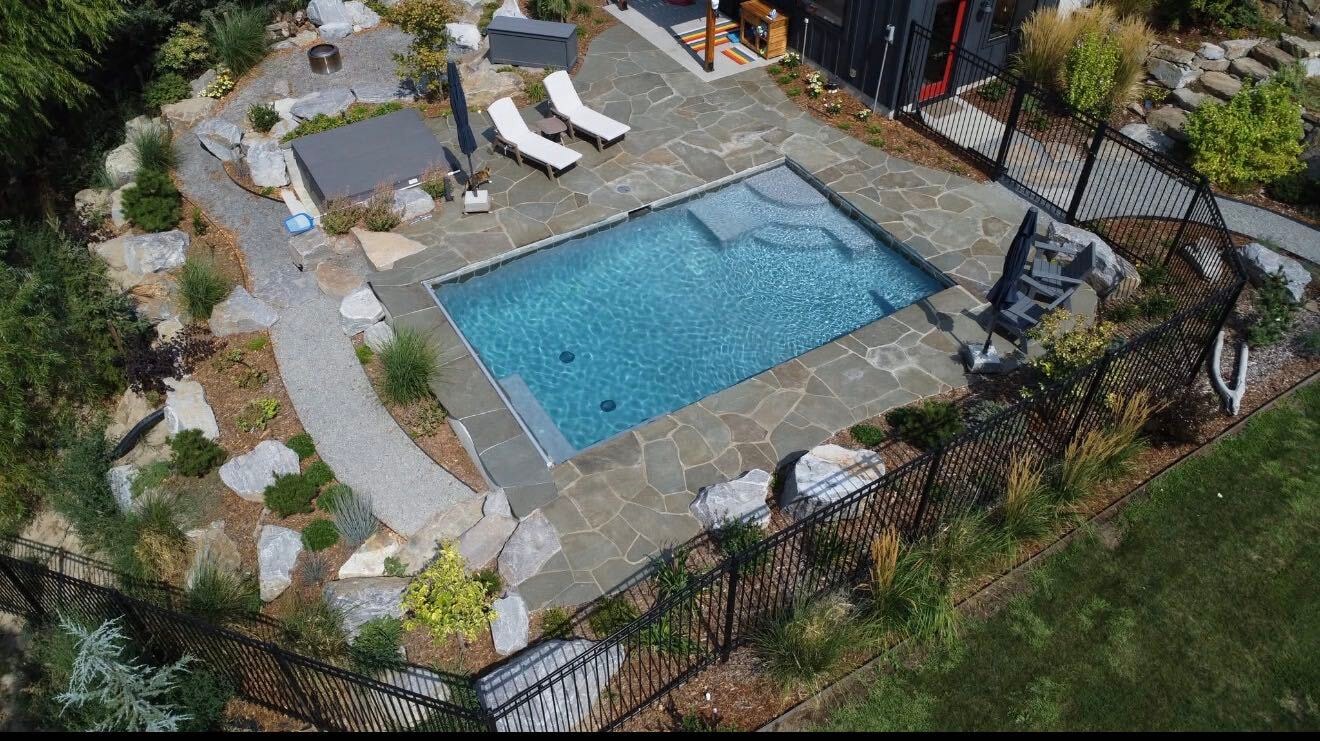 Aerial view of completed rectangular pool with flagstone patio and landscaping